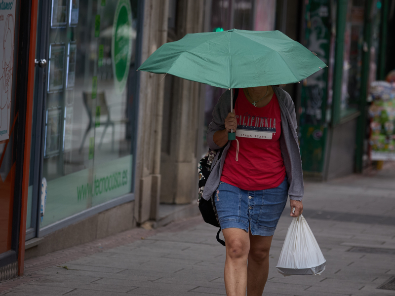 Una mujer se protege de la lluvia con un paraguas