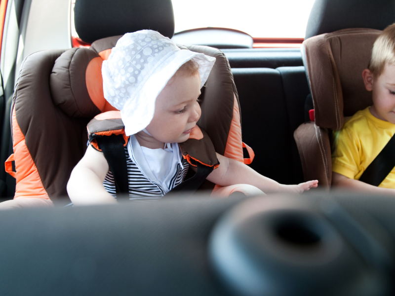 Dos niños pequeños en su silla de coche