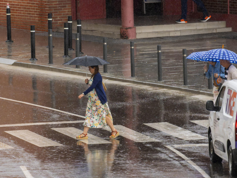 Varias personas se protegen de la lluvia a primera hora en Teruel