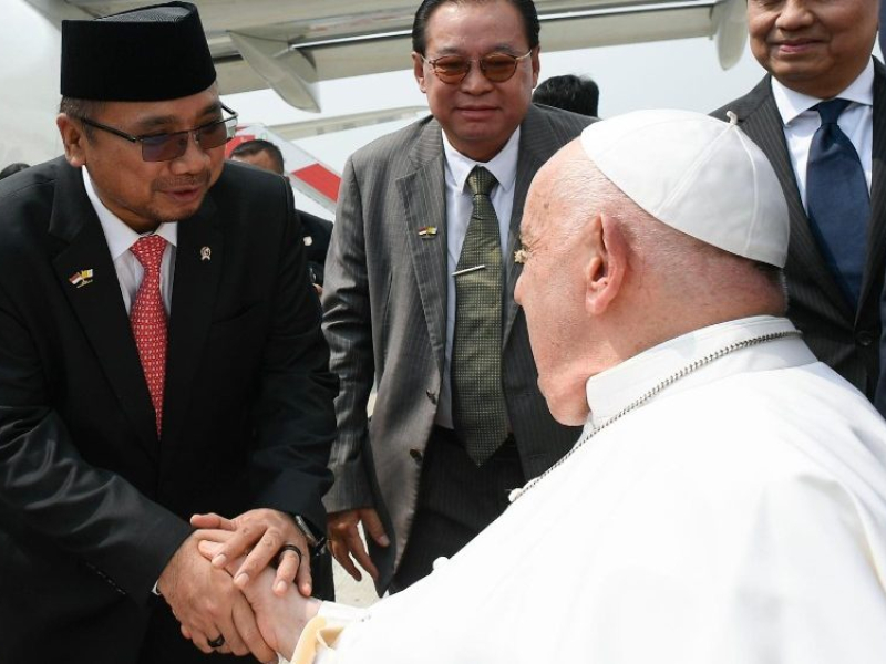 El Papa Francisco saluda a los miembros de la tripulación del vuelo hacia Papúa Nueva Guinea