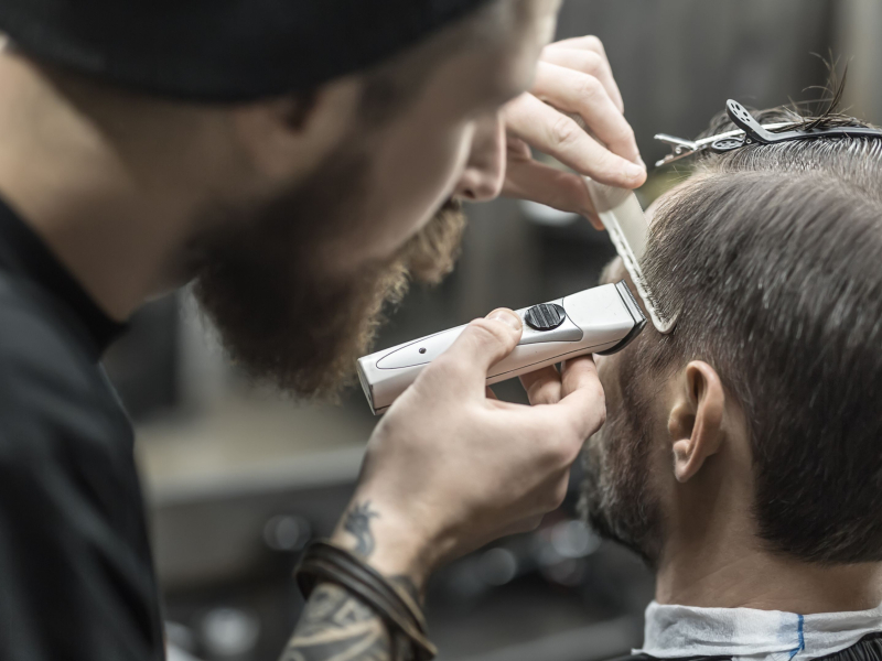 Peluquero corta el pelo a un cliente