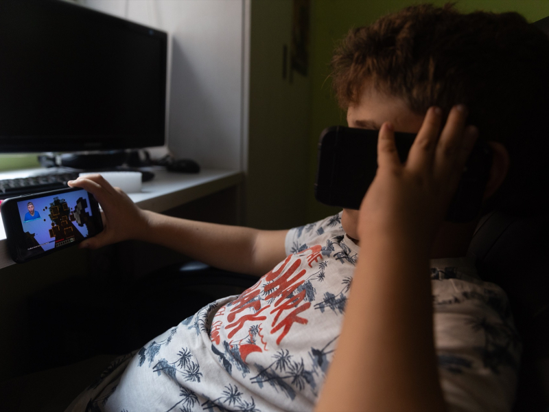 Un niño usa el teléfono móvil y una tablet