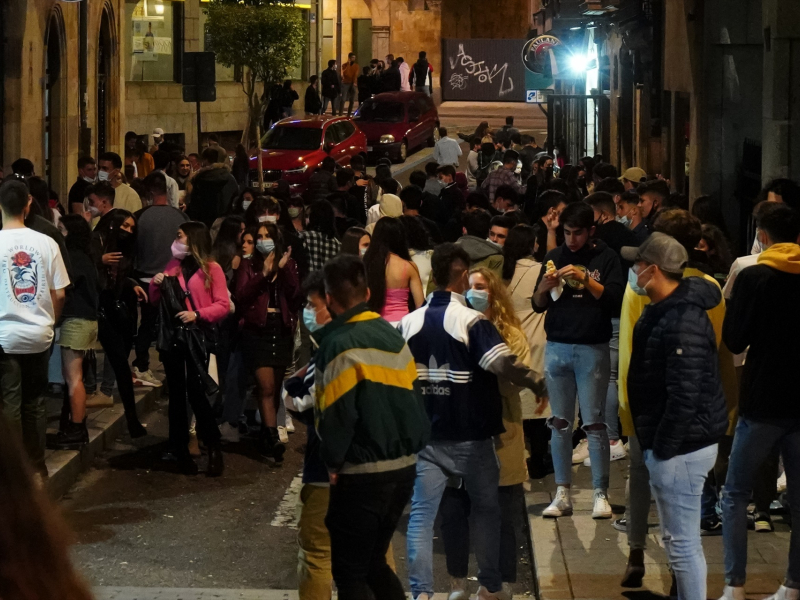 Varias personas se juntan en ambiente festivo, en una céntrica calle de Salamanca