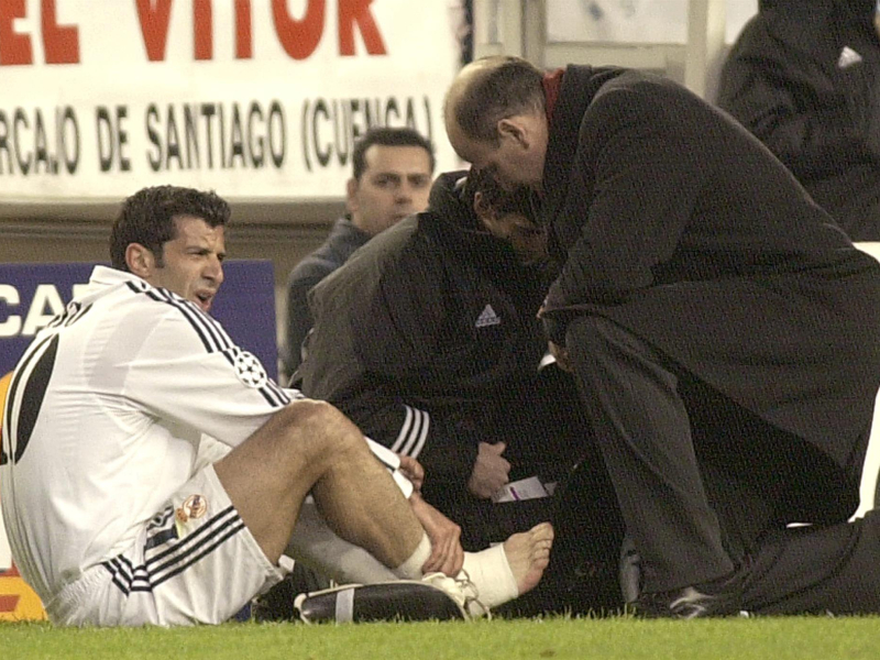 Del Corral atiende a Luis Figo en un partido de Champions