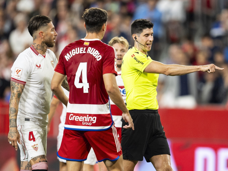 Busquets Ferrer, árbitro, gesticula durante el partido de fútbol de LaLiga EA Sports disputado entre el Sevilla FC y el Granada CF en el Ramón Sánchez-Pizjuán