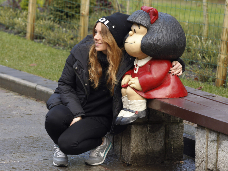 Una joven se saca una foto junto a la escultura de Mafalda en Oviedo