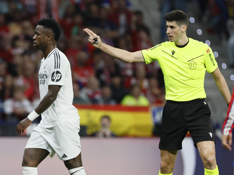 MADRID, 29/09/2024.- El árbitro Busquets Ferrer (d) y el delantero del Real Madrid Vinicius Junior, durante el partido de la LaLiga EA Sports que Atlético de Madrid y Real Madrid disputan este domingo en el estadio Civitas Metropolitano. EFE/Ballesteros