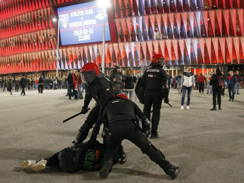 GRAF7569. BILBAO, 22/02/2018.- Agentes de la brigada móvil de la Ertzaintza, detienen a un aficionado tras varias cargas momentos antes de comenzar el partido entre el Athletic Bilbao- Spartak de Moscú, de vuelta de dieciseisavos de final de la Liga Europa disputado en San Mamés. EFE/LUIS TEJIDO