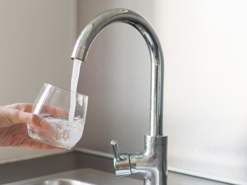 Una persona echando agua en un vaso