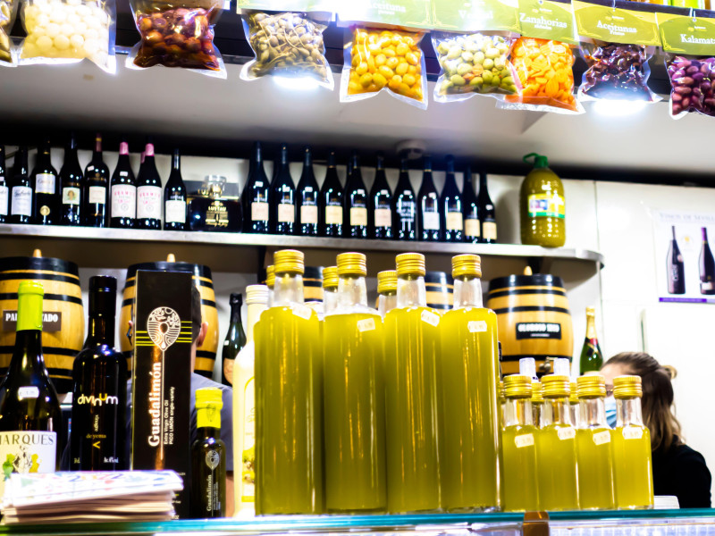 Aceite de oliva embotellado en un puesto de exposición en el Mercado de Triana, Sevilla, Andalucía, España