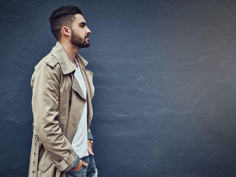 Estilo urbano para el hombre urbano. Imagen de un joven elegante con ropa urbana posando frente a una pared gris.