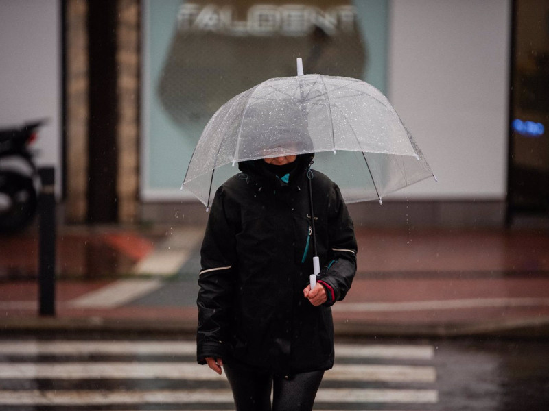 Una persona se protege de la lluvia con paraguas