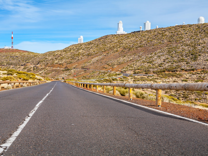 2A9X17N Road through volcanic landscape of Teide National Park. Astronomical observatory on backdrop. Tenerife, Canary Islands, Spain