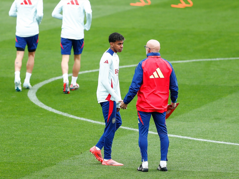 Lamine Yamal de España y Luis de la Fuente, entrenador de España, hablan durante una sesión de entrenamiento previa a los partidos de la Liga de Naciones de la UEFA de la selección española de fútbol en la Ciudad del Fútbol el 8 de octubre de 2024, en Las Rozas, Madrid.