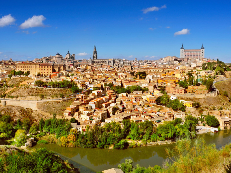 Una vista panorámica de Toledo, España, con el río Tajo en primer plano y el imponente Alcázar al fondo.