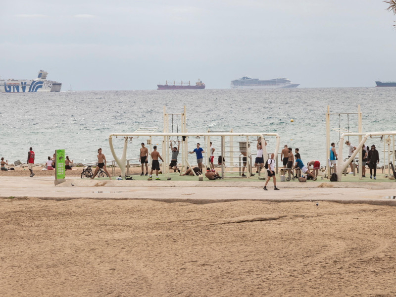 Personas haciendo ejercicio en un gimnasio de playa al aire libre en la playa de La Barceloneta