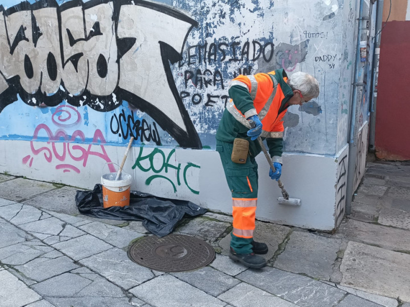 Un operario de EMULSA limpia una fachada de Cimadevilla