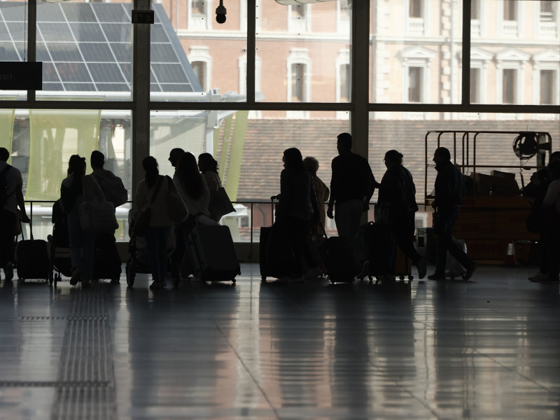 Varias personas esperan para montar en tren en la estación de Atocha en Madrid este domingo. Renfe ha suprimido este domingo diversos trenes entre Madrid, la Comunitat Valenciana y Murcia debido a una incidencia con un tren sin pasajeros ocurrida ayer sábado en el túnel de alta velocidad que une las estaciones madrileñas de Atocha y Chamartín