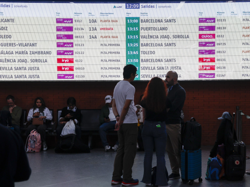 Varias personas esperan la salida de su tren en la estación de Atocha en Madrid este domingo. Renfe ha suprimido este domingo diversos trenes entre Madrid, la Comunitat Valenciana y Murcia debido a una incidencia con un tren sin pasajeros ocurrida ayer sábado en el túnel de alta velocidad que une las estaciones madrileñas de Atocha y Chamartín