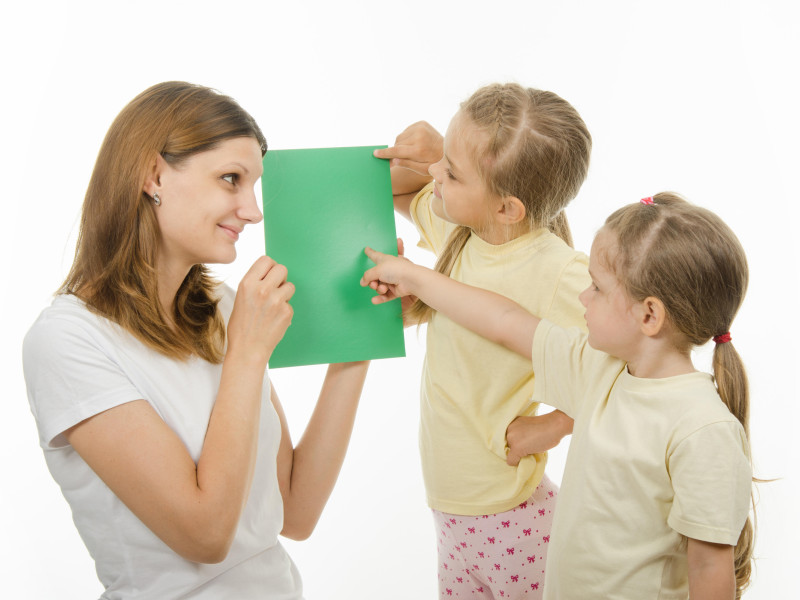 La madre muestra a sus dos hijas imágenes en color para comprobar si distinguen los colores.