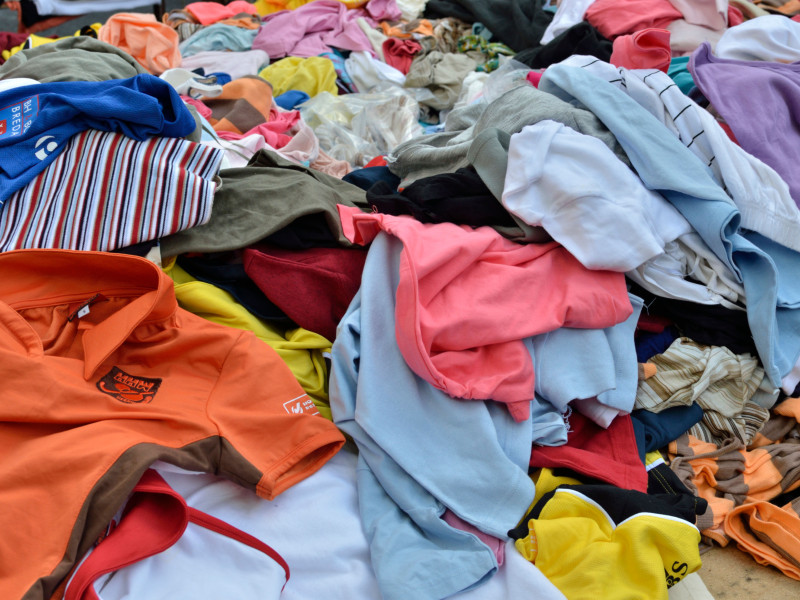 Una pila de ropa de segunda mano en un puesto de mercado.