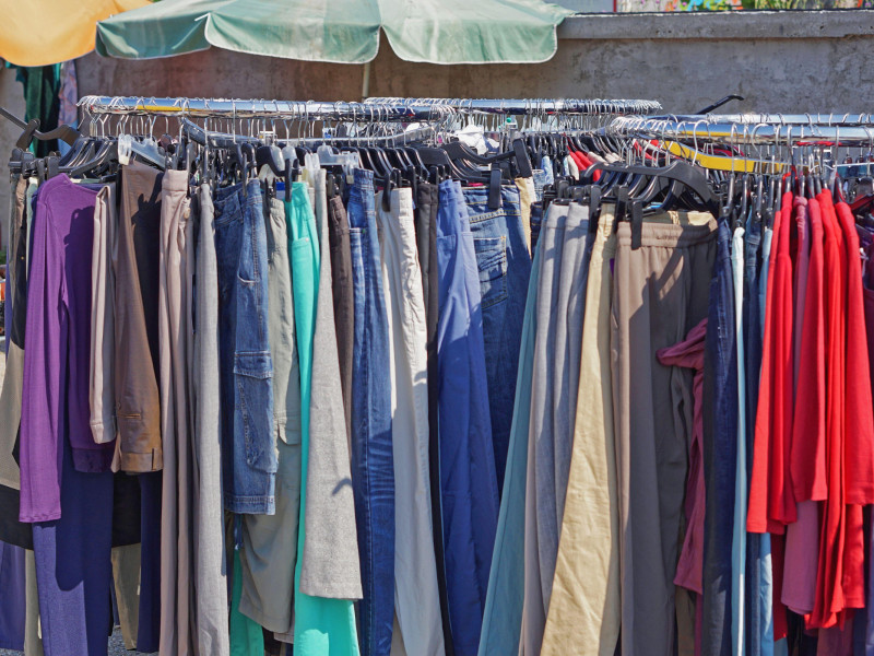 Pantalones y faldas colgados en percheros de un mercadillo