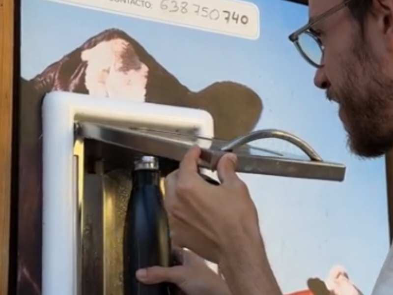 Un joven poniendo una botella en el dispensador