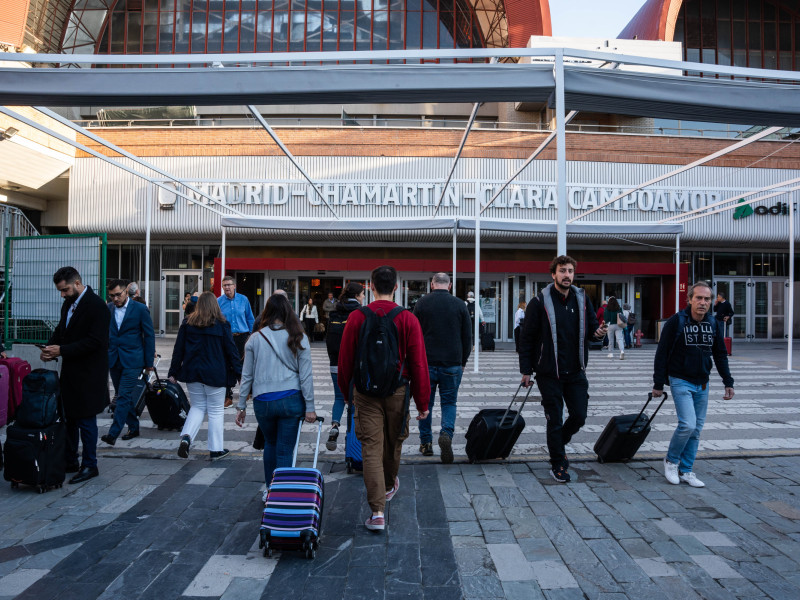 Varias personas con maletas en la puerta de la estación de tren de Chamartín