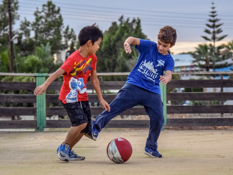 Dos niños juegan al fútbol