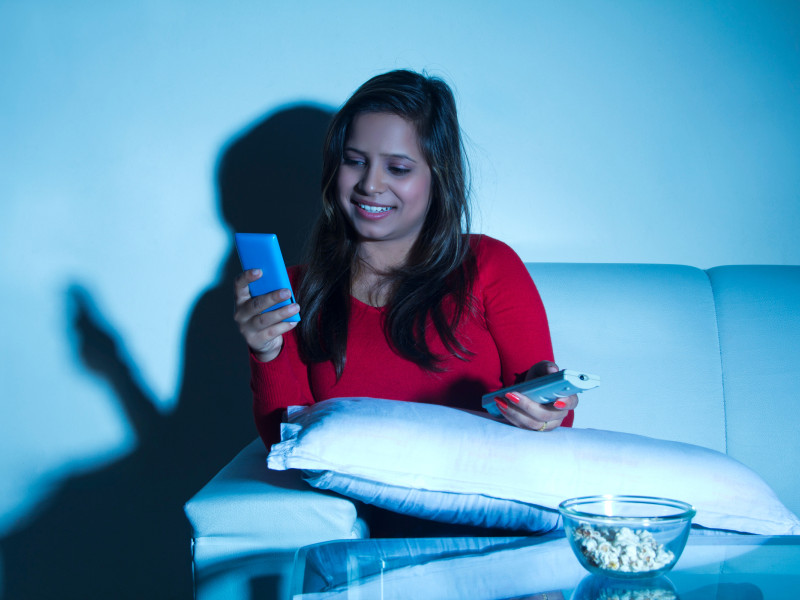 Chica en casa mirando el teléfono