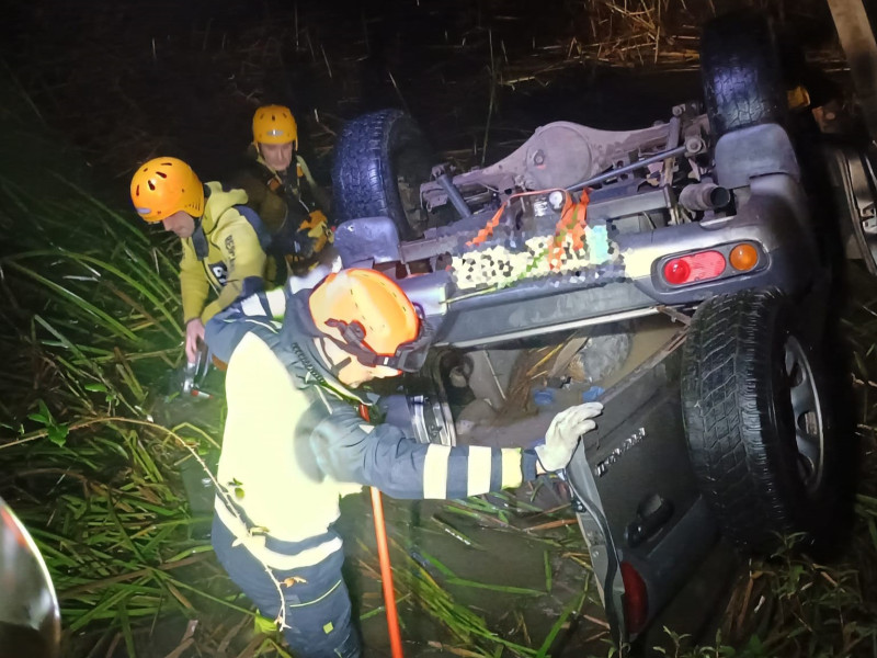 Los bomberos junto al vehículo accidentado