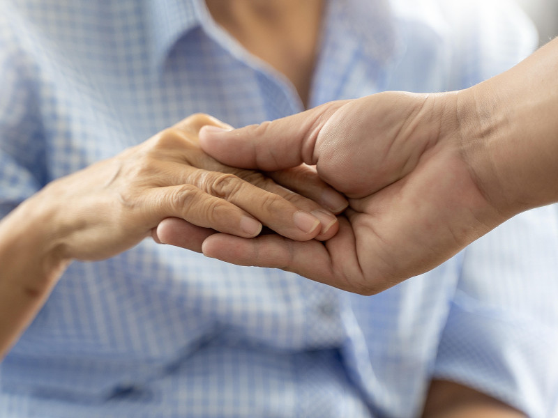 Personas, anciana y joven, tomados de la mano, discapacitados, caminando con ayuda