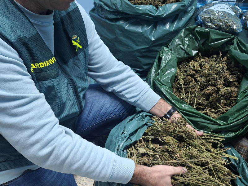 Agente de la Guardia Civil con las bolsas de marihuana intervenidas