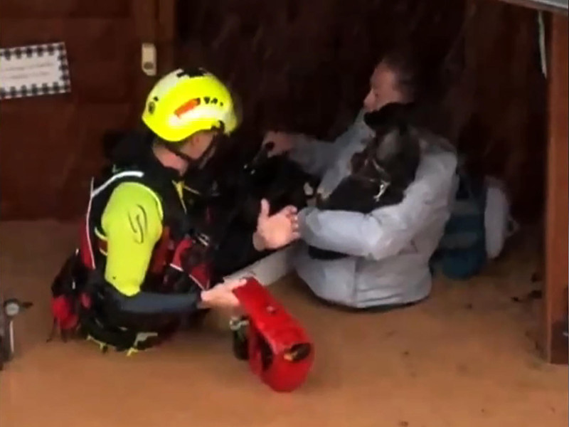 Captura de video cedido por @JaviNakama_ que muestra un integrante de las fuerzas de socorro rescatando a una mujer dentro de una inundación en Valencia