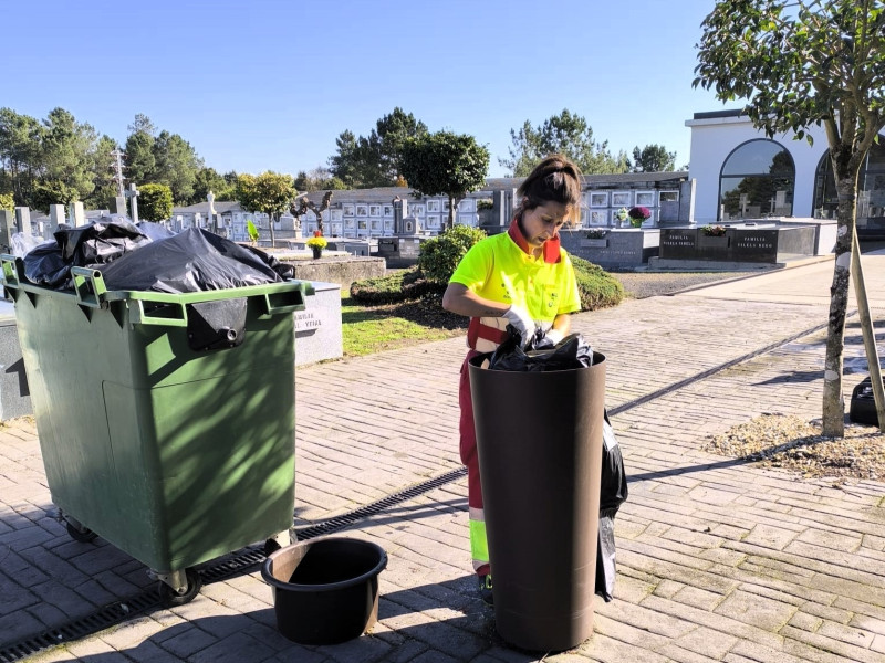 Una operaria municipal realiza labores del limpieza en el cementerio