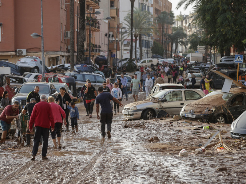 Varias personas caminan por una de las calles afectadas en Paiporta, tras las fuertes lluvias causadas por la DANA. La alcaldesa de Paiporta (Valencia), Maribel Albalat, ha confirmado que al menos hay 34 fallecidos en su municipio a consecuencia de la dana que ha afectado a la Comunidad Valenciana. EFE/Manu Bruque