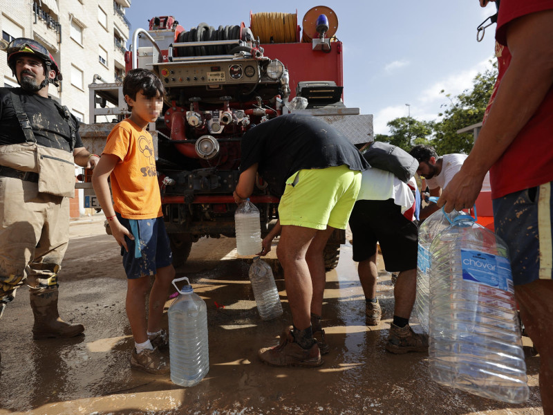 PAIPORTA (VALENCIA), 31/10/2024.- Vecinos de Paiporta recogen agua potable de un camión de la UME, este jueves. La Comunitat Valenciana intenta recuperarse de la peor dana del siglo en España, que ha dejado casi un centenar de muertos en esa región, además de un inmenso escenario de daños en carreteras, calles e infraestructuras de numerosas localidades. EFE/Manuel Bruque