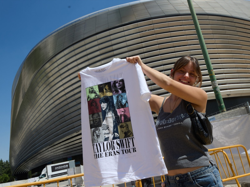 Una mujer sujeta una camiseta de merchandaising, en los alrededores del Estadio Santiago Bernabéu, a 28 de mayo de 2024, en Madrid (España)