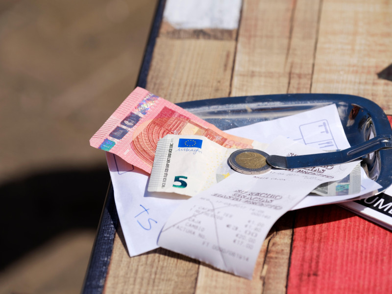 Una cuenta de bar o comida pagada que se dejó en una fuente con un recibo en la mesa de un restaurante. El cliente pagó en euros y dejó una propina.