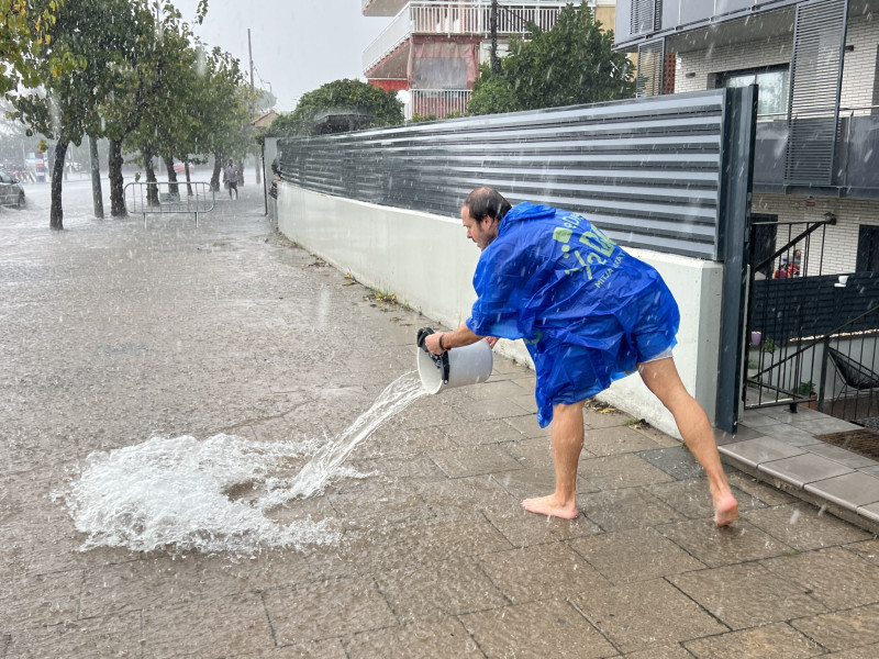 Vecino intenta achicar agua de su casa