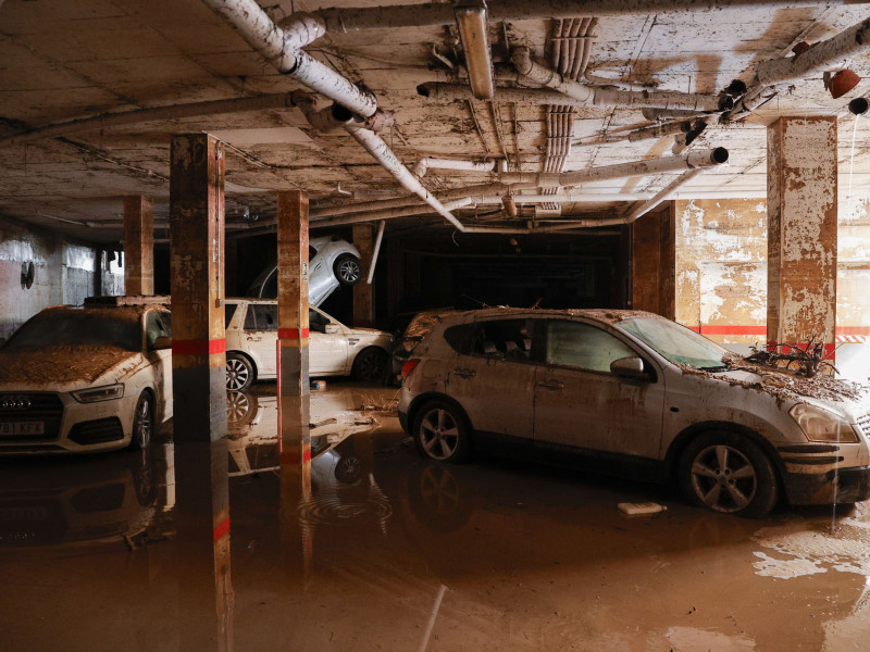 VehÍculos en el interior de un garaje del que ya se ha achicado todo el agua este lunes en Paiporta