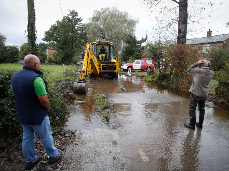 Una excavadora y un vehículo de los Bomberos trabajan achicando el agua de una vivienda inundada por el desbordamiento del río Anllo, a 9 de octubre de 2024, en Xuvín, Abadín, Lugo, Galicia