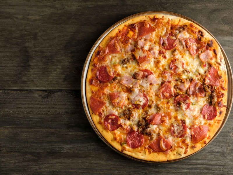 Un festín de carne casera, pizza de masa fina al horno de piedra