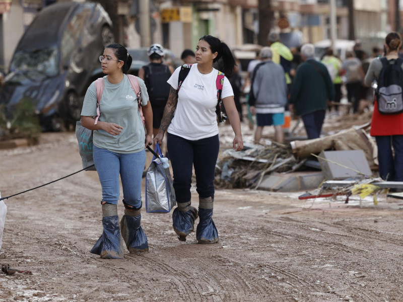 Dos chicas pasean por Paiporta con sus pertenencias y su perro