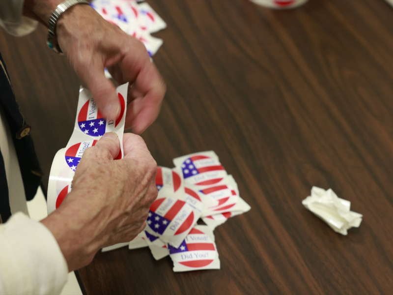 Una persona revisa las pegatinas de "Yo voté" en un centro de votación en la Iglesia Católica San Juan Apóstol en Bloomington, durante las elecciones presidenciales estadounidenses de 2024.