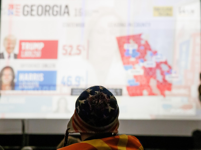 Un invitado con gorra con estrellas y rayas observa la cobertura electoral durante una noche de elecciones estadounidenses con demócratas en el extranjero en Berlín, Alemania, el 5 de noviembre de 2024