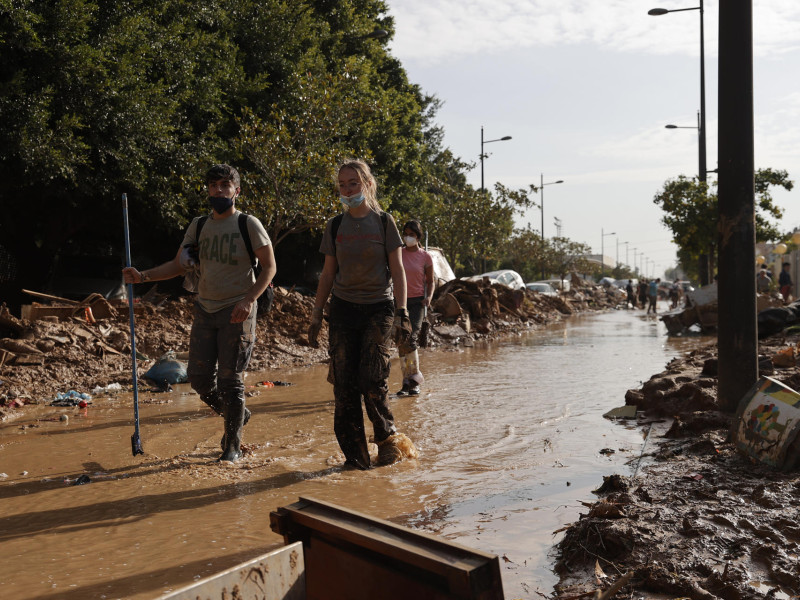 Varios voluntarios trabajan para despejar una calle de Paiporta