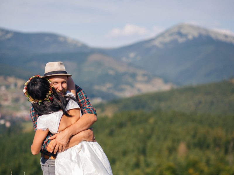 Boda en las montañas. Feliz pareja de enamorados abrazándose.