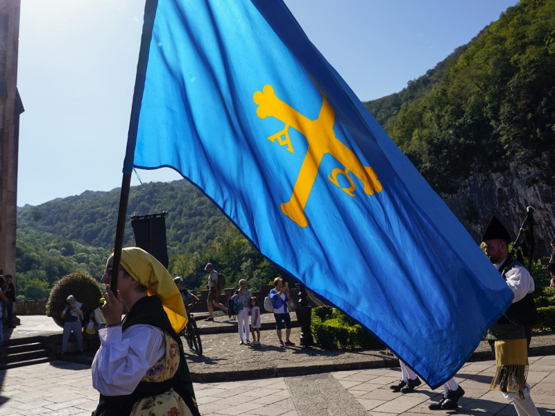 Una chica lleva la bandera de Asturias en Covadonga