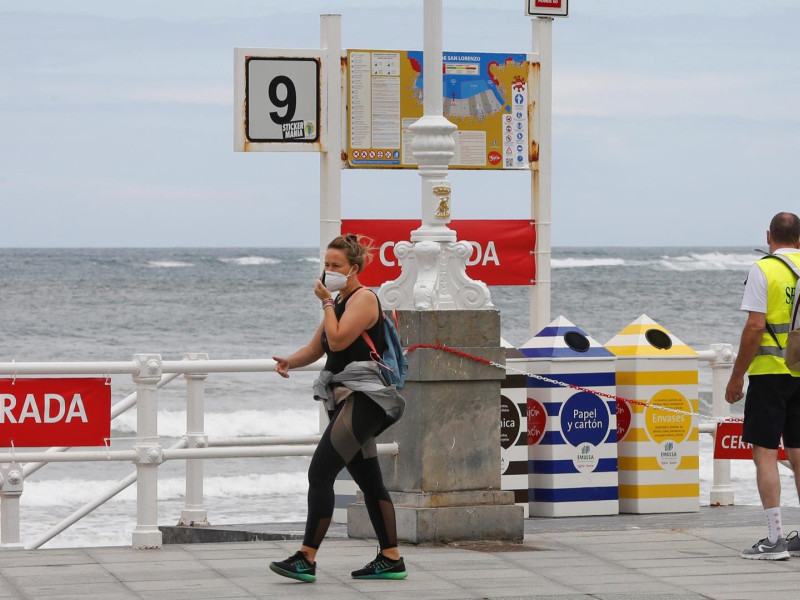 Dos serenos de Gijón vigilan el acceso a la playa de San Lorenzo durante la pandemia